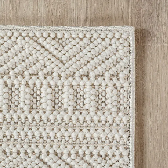 Flachgewebeteppich Helix 2202 - Creme, 250 x 80 cm, 100 % Polyester - Detailaufnahme eines beigen Teppichs mit einer dekorativen, getufteten Oberfläche, die eine gemütliche und stilvolle Textur zeigt.