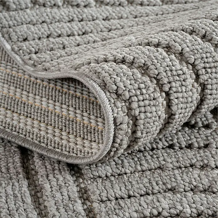 Flachgewebeteppich Helix 2201 - Silber, Durchmesser: 80 cm, 100 % Polyester - Nahaufnahme eines grauen Badteppichs mit Noppenstruktur und gewickeltem Rand.