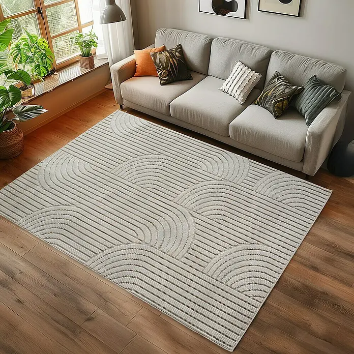 Flachgewebeteppich Helix 2201 - Creme, 290 x 200 cm, 100 % Polyester - Ein modernes Wohnzimmer mit einem beigen Sofa und einem geometrisch gemusterten Teppich.
