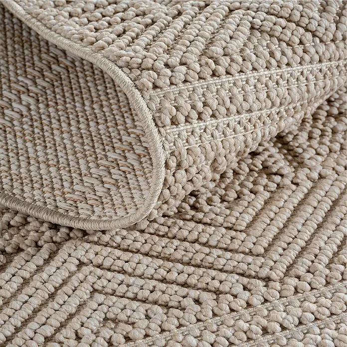 Flachgewebeteppich Helix 2202 - Beige, 200 x 140 cm, 100 % Polyester - Detailaufnahme eines beigefarbenen Teppichs mit gewebter Struktur und umgeschlagenem Rand, der die Textur hervorhebt.