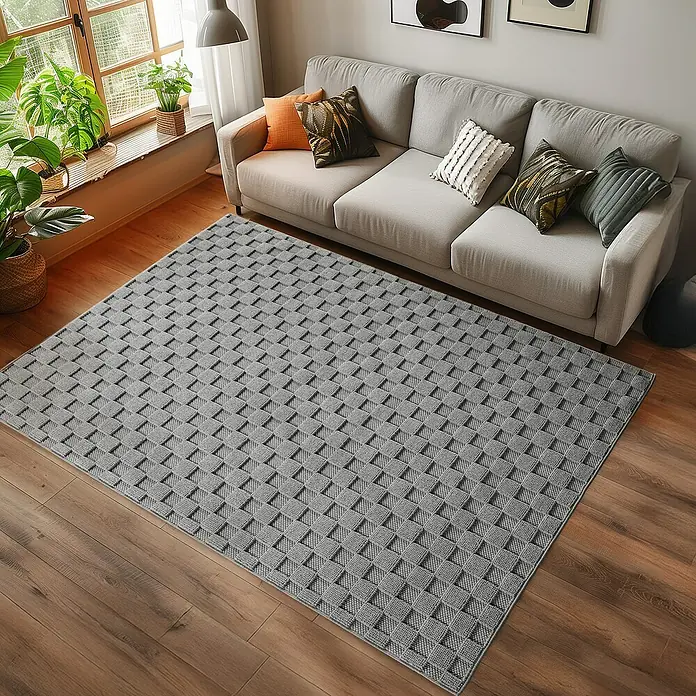 Flachgewebeteppich Helix 2203 - Silber, 230 x 160 cm, 100 % Polyester - Grauer Teppich mit geometrischem Muster vor einem Sofa. Der Teppich verleiht dem Raum Struktur und ein modernes Aussehen.