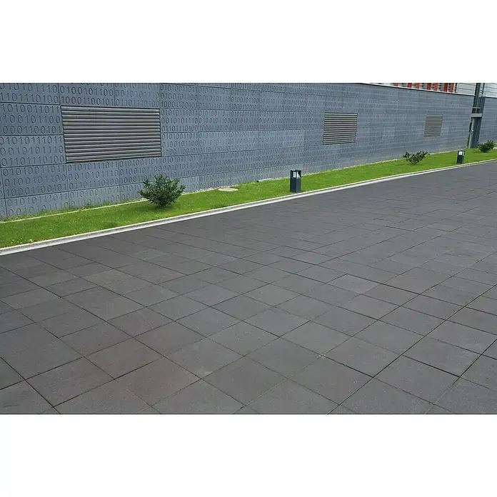 EHL Gehwegplatte - 40 x 40 x 4 cm, Anthrazit, Beton - Außenansicht eines Gebäudes mit binärem Code und quadratischen Pflastersteinen, die einen modernen und technisch inspirierten Raum schaffen.