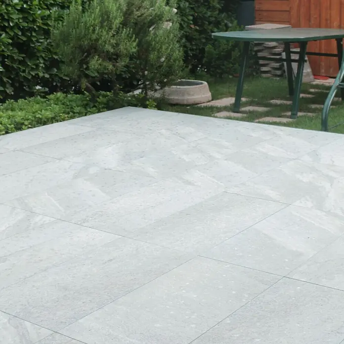 Terrassenfliese Quarzo Silver - 40 x 80 x 2 cm, Silber, Matt - Ein detailreiches Bild von Terrassenfliesen im Außenbereich, die eine ebene, hellgraue Oberfläche für Entspannung im Freien bieten.