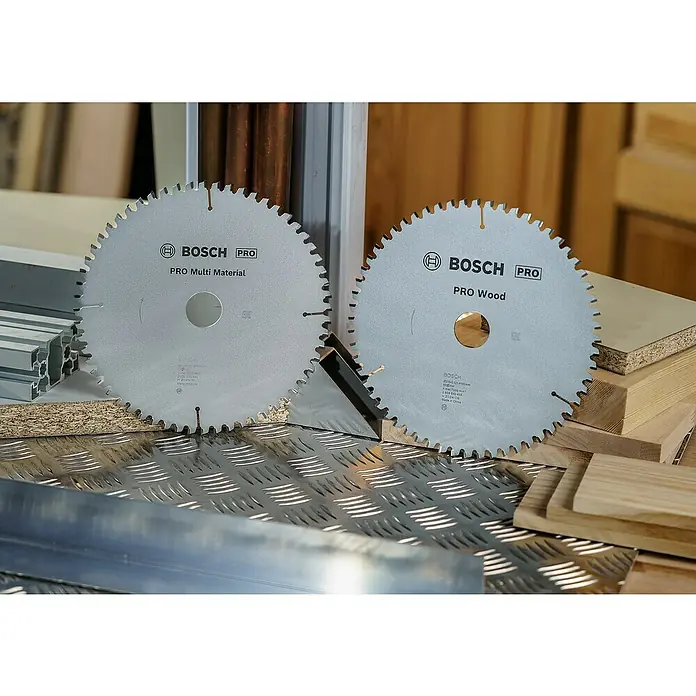 Bosch Professional Kreissägeblatt - Durchmesser Sägeblatt: 216 mm, Bohrung: 30 mm, 2 Stk. - Nahaufnahme von zwei Bosch Pro Kreissägeblättern, eines für Multimaterialien und eines für Holz, auf einer Werkbank.