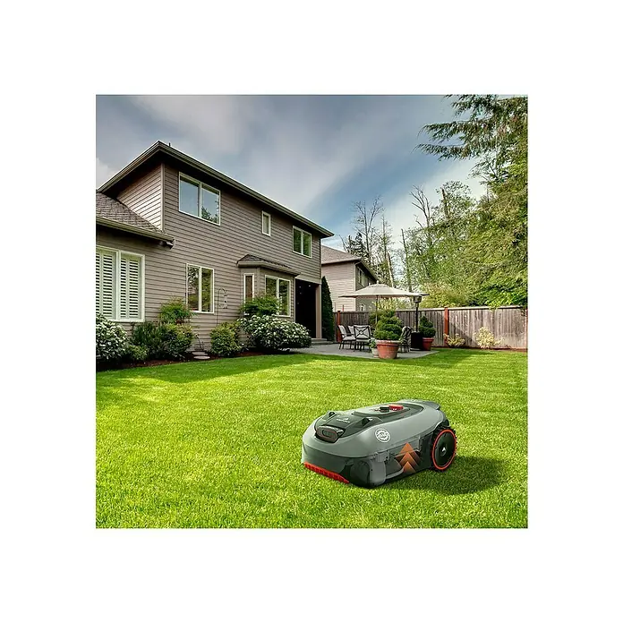 Yard Force Mähroboter Revola iVR10 - 1.000 m², Schnittbreite: 18 cm, Induktionsgestützte Navigation, Begrenzungskabel - Ein Rasenmäherroboter auf einem Rasen vor einem Haus. Der Roboter ist grau und orange.