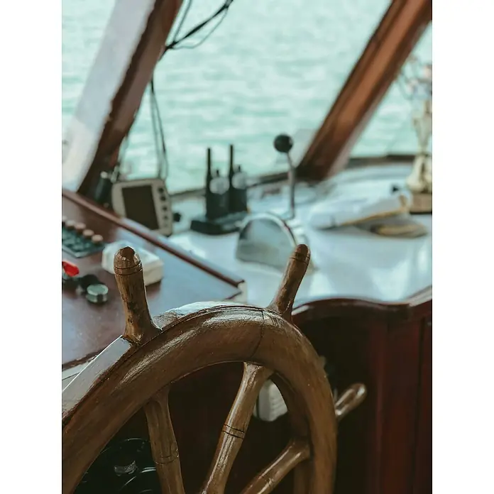 Papel higiénico Aqua Soft - Número de ruedas: 4 ud., Número de hojas: 250 ud. - Primer plano de un timón de madera en un barco, que encarna la tradición marítima y la artesanía.