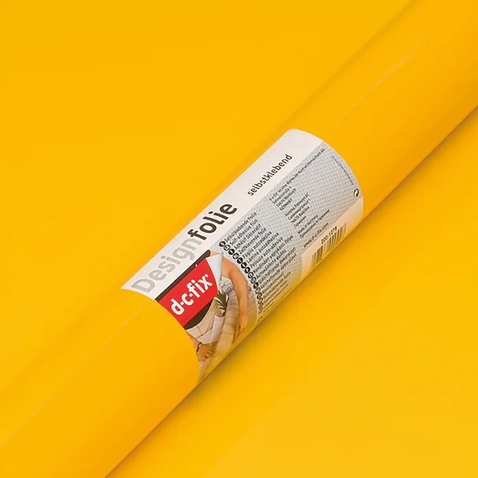 D-c-fix Dekorfolie Uni Lack - 45 x 200 cm, Uni, Bananen-Gelb - Nahaufnahme einer Rolle gelber selbstklebender Dekorfolie von d-c-fix auf gelbem Hintergrund, ideal für DIY-Projekte und Renovierungen.