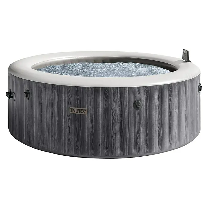Intex Pure Spa Hidromasaje móvil Greenwood - Ø x Al: 216 x 71 cm, Gris/Blanco, 1.098 l - Un jacuzzi redondo Intex con decoración de madera gris y borde blanco, lleno de agua burbujeante para momentos relajantes en el jardín.