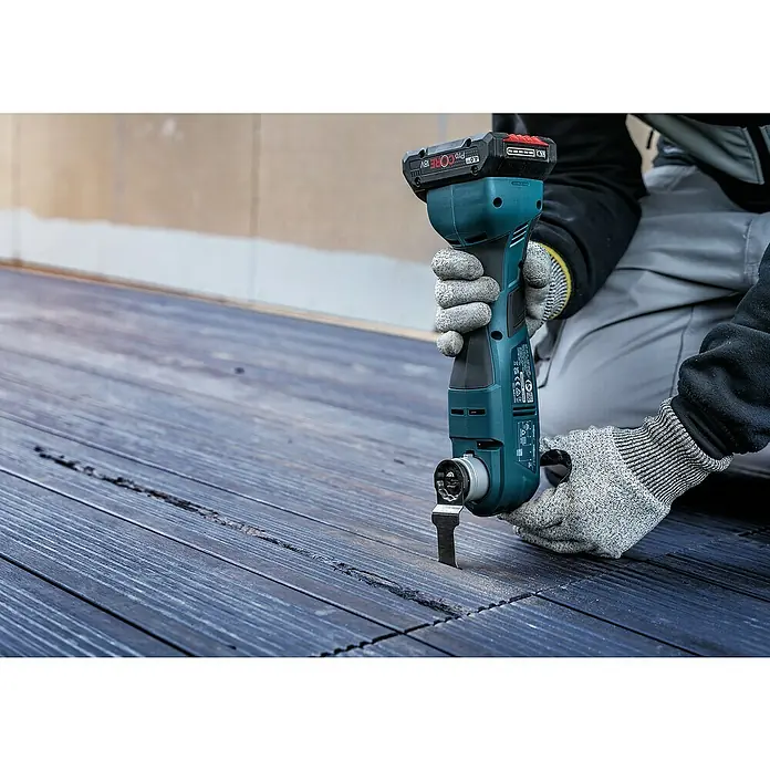 Bosch Expert Hoja de sierra de inmersión Multimax AIZ 32 APLIT - Ancho: 32 mm, Acero - Una persona usa una multiherramienta inalámbrica Bosch para trabajar en una superficie de madera. La herramienta es azul y negra.