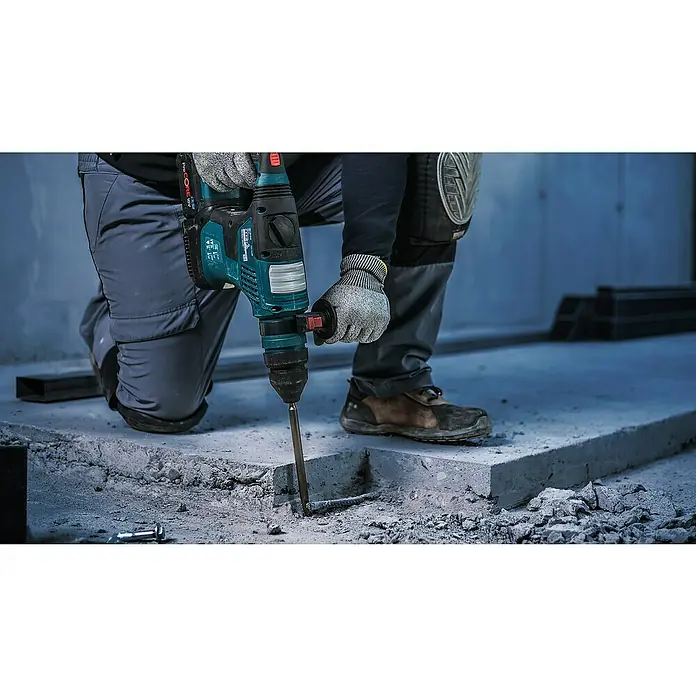 Bosch Meißel-Set Pro SDS Plus-4C - 250 mm, 4 -tlg. - Ein Arbeiter bohrt mit einem blauen Bohrhammer in Beton. Gut geeignet für Heimwerker- und Bauprojekte, die professionelle Werkzeuge erfordern.
