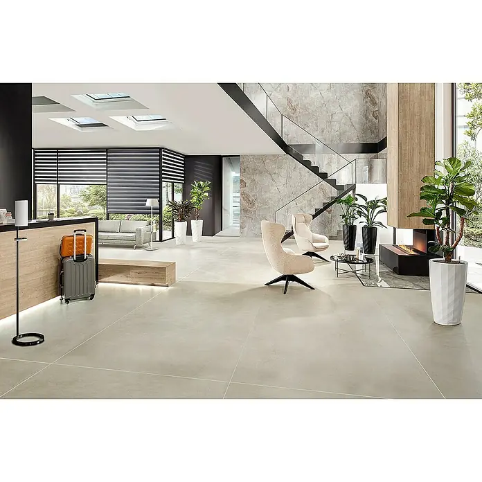 Lechuza Pflanzsäule rund Rondo Premium - Außenmaß (Ø x H): 32,5 x 56,5 cm, Kunststoff, Anthrazit Metallic - Elegantes Hotellobby-Interieur mit stilvollen Sesseln, Gepäck und Zimmerpflanzen auf einem hellen Steinboden. Moderne Architektur mit Treppe und Oberlichtern.