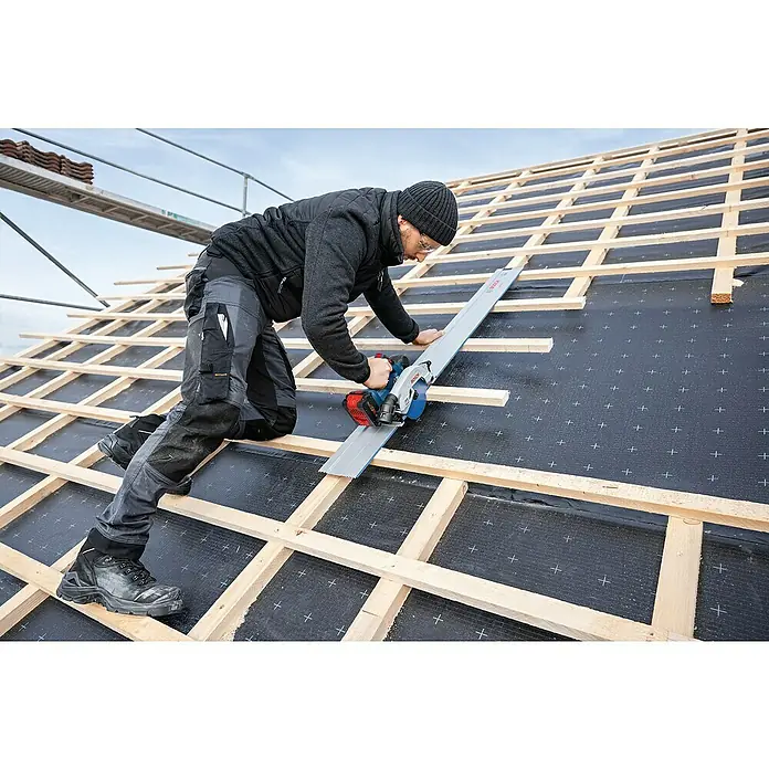Bosch Professional AMPShare 18V Akku-Handkreissäge Pro Heavy Duty GKS 18V-57-2 GX - 18 V, Ohne Akku, Durchmesser Sägeblatt: 165 mm, 5.000 U/min - Ein Zimmermann arbeitet mit einer Bosch-Kreissäge auf einem Dach, um Holzlatten zuzuschneiden, wobei er eine Führungsschiene verwendet.