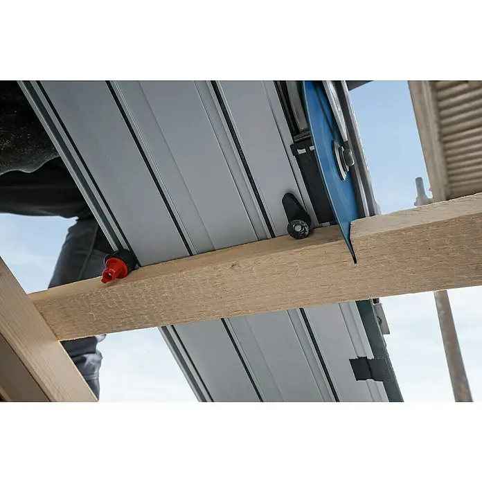 Bosch Professional AMPShare 18V Akku-Handkreissäge Pro Heavy Duty GKS 18V-57-2 GX - 18 V, Ohne Akku, Durchmesser Sägeblatt: 165 mm, 5.000 U/min - Graue Führungsschiene mit blauem Sägeblatt sägt ein Holzbrett. Ein roter Anschlag ist angebracht.