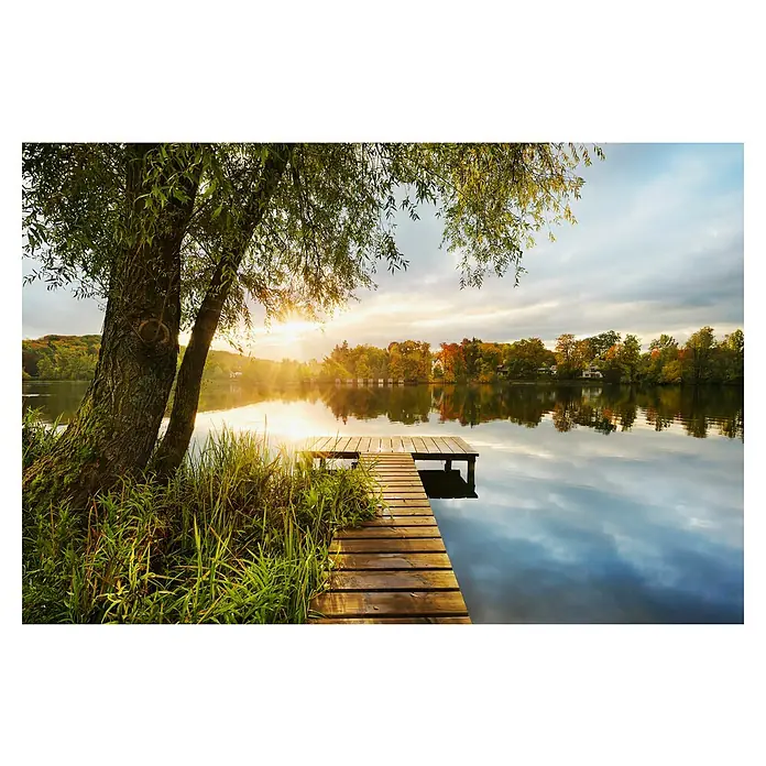 Komar Fototapete Picnic - 4 -tlg., B x H: 368 x 248 cm, Vlies - Holzsteg an einem ruhigen See bei Sonnenauf-/untergang, mit großem Baum und Häusern im Hintergrund, die sich im Wasser spiegeln.