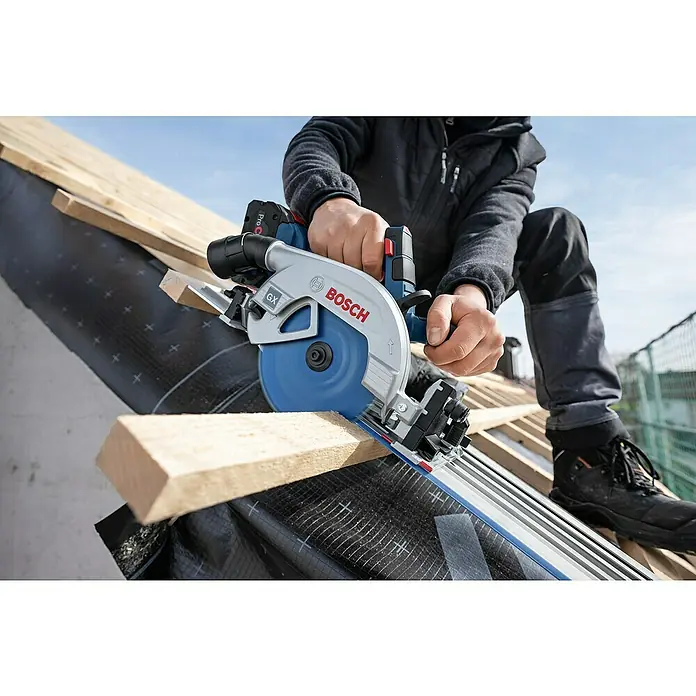 Bosch Professional AMPShare 18V Akku-Handkreissäge GKS 18V-57-2 GX PRO SOLO - 18 V, Ohne Akku, Durchmesser Sägeblatt: 165 mm, 5.000 U/min - Ein Handwerker schneidet Holz mit einer Bosch Akku-Tauchsäge GKT 18V-52 GC auf einer Baustelle, wobei Präzision im Vordergrund steht.