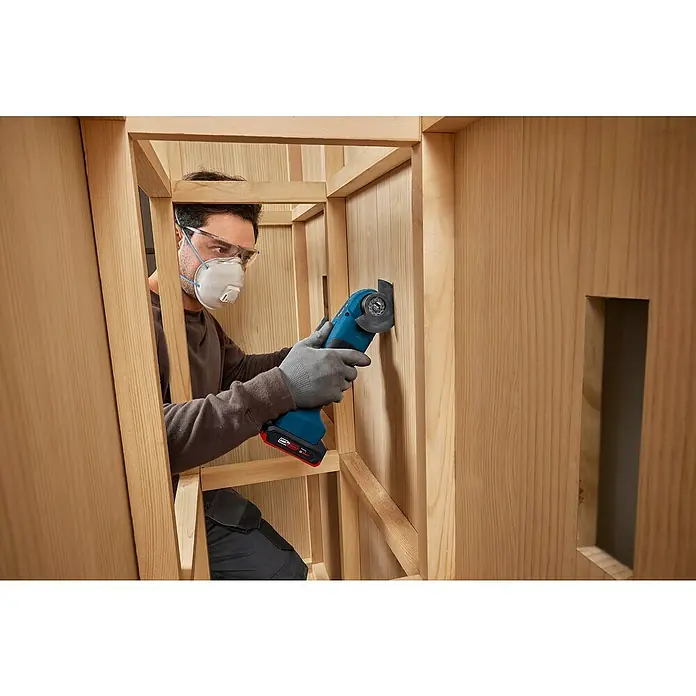 Bosch Professional AMPShare 18V Akku-Multitool GOP 18V-30 SOLO K - Ohne Akku, 18 V - Ein Handwerker benutzt ein Bosch Multifunktionswerkzeug, um präzise Arbeiten an einem Holzrahmen durchzuführen. Schutzkleidung wird getragen.