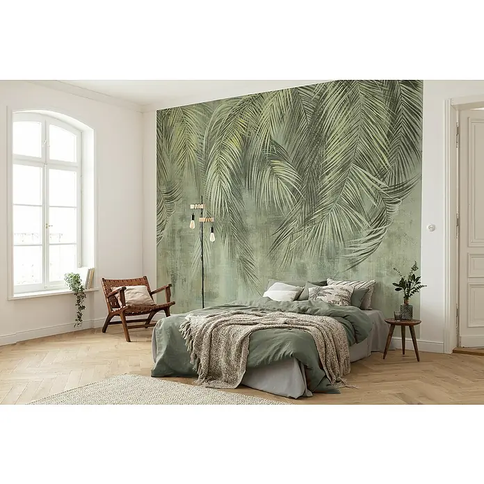 Komar Fototapete Palmenhain - 7 -tlg., B x H: 350 x 250 cm, Vlies - Schlafzimmer mit grüner Bettwäsche und floraler Wandtapete. Die grüne Bettwäsche ergänzt das florale Muster der Wand und verleiht dem Raum eine ruhige Atmosphäre.