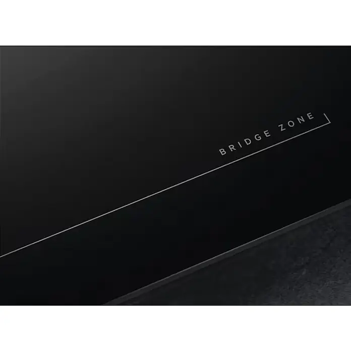AEG Placa de cocción TO63IQ00FB - Número de fogones de inducción: 3 ud., Vidrio - Primer plano de una placa de cocción negra con el texto 'BRIDGE ZONE' y un fino detalle de línea blanca.