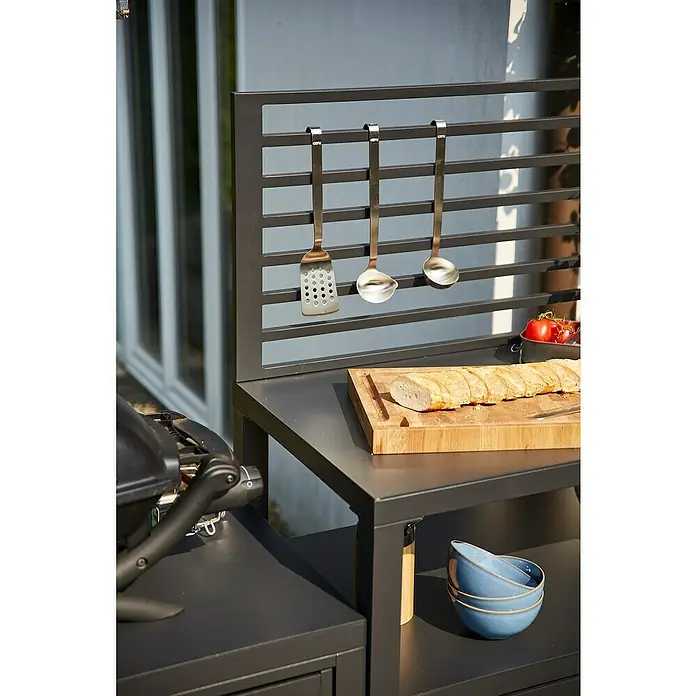 Siena Garden Outdoorküche Texas - 2 -tlg., Anthrazit - Dunkelgraue Outdoor-Küchenzeile mit hängenden Utensilien, Schneidebrett mit Baguette und Schalen in einem Außenbereich.