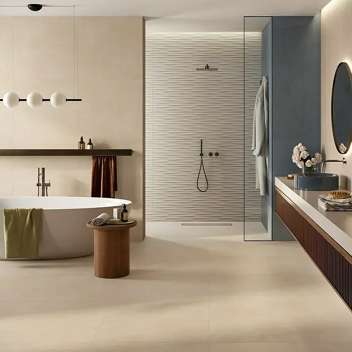 Atlas Concorde Solution Feinsteinzeugfliese Lexington - 80 x 80 cm, Lilium, Matt - Helle beigefarbene Fliesen an Boden und Wänden schaffen ein ruhiges, modernes Bad mit Wanne und texturiertem Duschbereich.