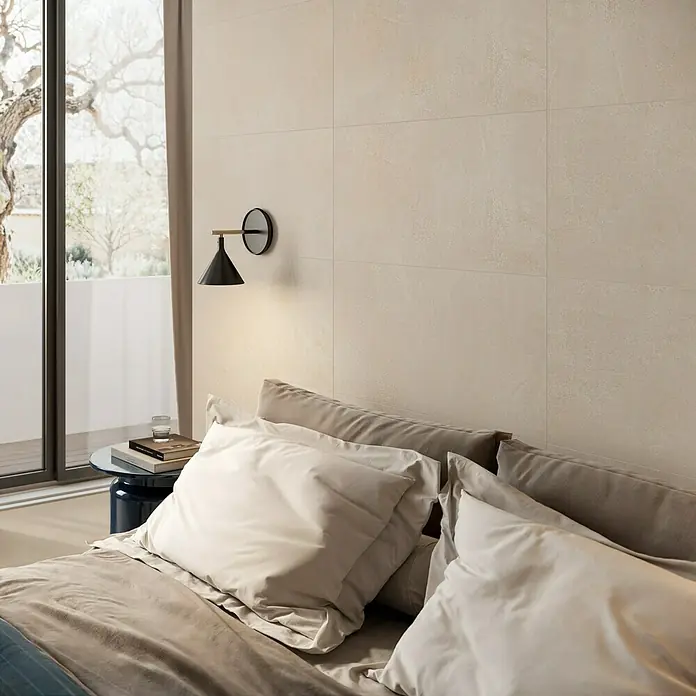 Corso Italia Wandfliese Lexington Lilium - 80 x 40 cm, Beige, Matt - Hellbeige strukturierte Fliesen an einer Schlafzimmerwand hinter einem Bett.