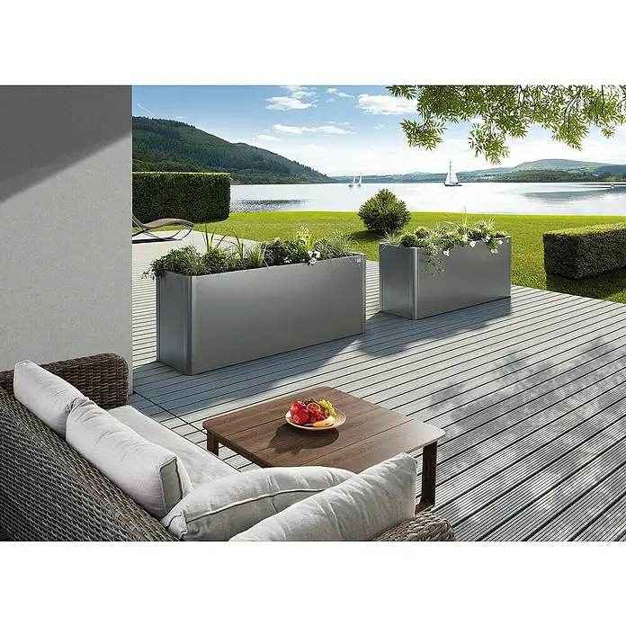Biohort Belvedere Hochbeet - 53 x 201 x 77 cm, Stahl, Quarzgrau Metallic - Zwei rechteckige graue Metall-Pflanzgefäße mit Pflanzen auf einer Terrasse, die einen Außenbereich am See verschönern.