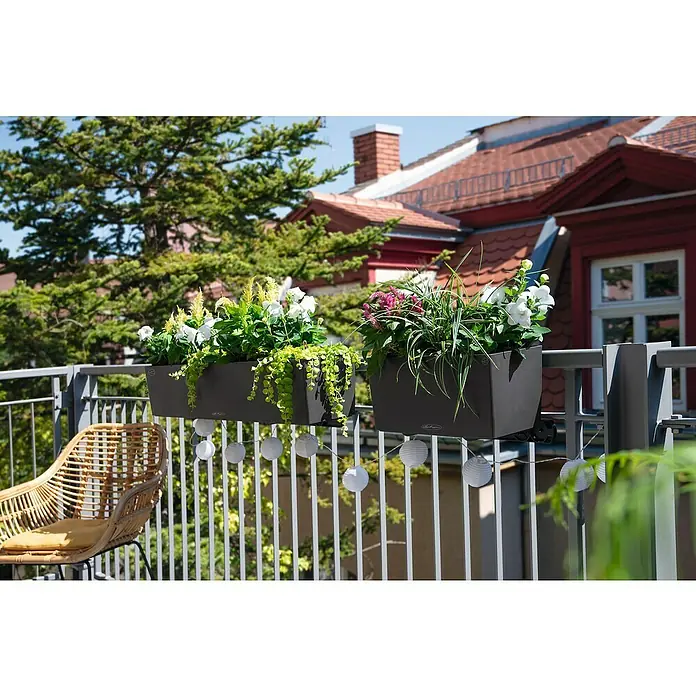 Lechuza Balconera Balkonkasten Color - Max. Außenlänge: 100 cm, Schiefergrau - Zwei dunkelgraue Balkonkästen, gefüllt mit bunten Blumen und Grünpflanzen, hängen an einem Metallgeländer in einem Außenbereich.
