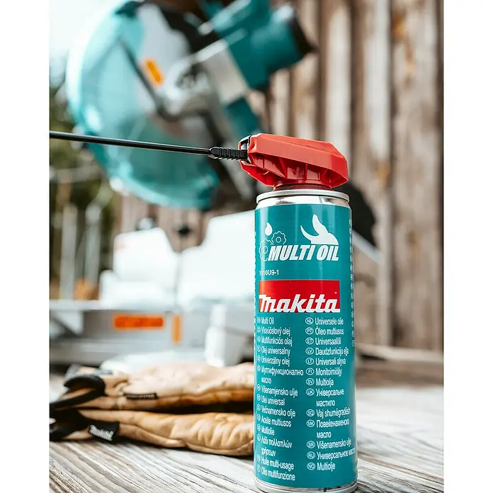 Makita Pflegespray - 0,3 l - Makita Multiöl Spraydose mit roter Düse und Sprührohr auf Holzarbeitsplatte, Werkzeuge im Hintergrund.