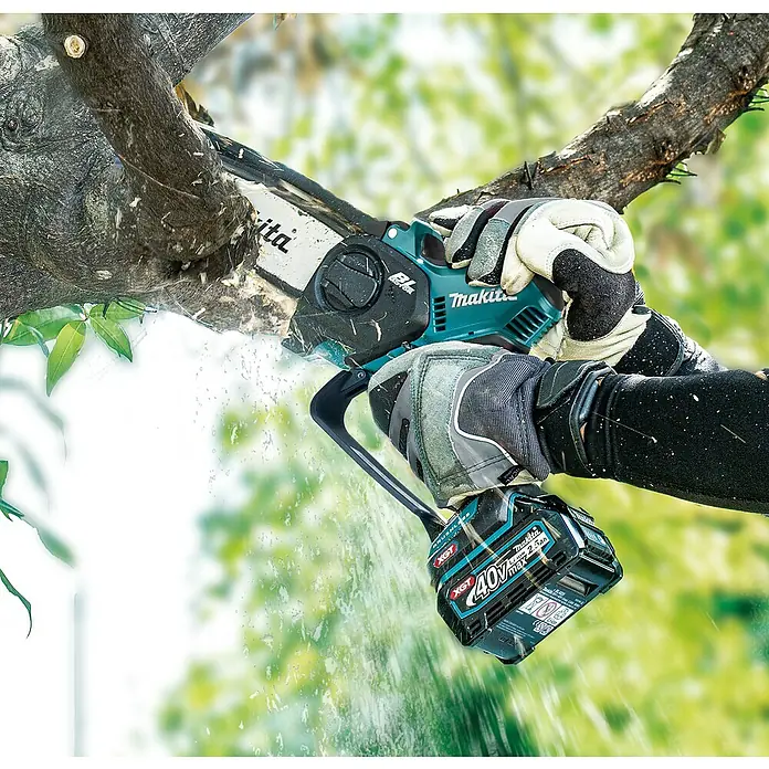 Makita XGT 40V max. Akku-Astsäge UC029GZ - 40 V, Li-Ionen, Ohne Akku, Schwertlänge: 150 mm - Behandschuhte Hände bedienen eine teal-schwarze Makita Akku-Kettensäge, die einen Ast schneidet. Sägemehl fliegt.