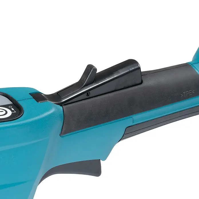 Makita XGT 40V max. Akku-Heckenschere UN001G - 40 V, Li-Ionen, Ohne Akku, Schnittlänge: 600 mm - Nahaufnahme eines türkisfarbenen Elektrowerkzeuggriffs mit schwarzem Sicherheitsschalter und Auslösemechanismus.