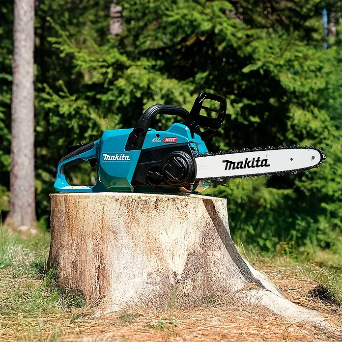 Makita XGT 40V max. Akku-Kettensäge UC022GZ - 40 V, Li-Ionen, Ohne Akku, Schwertlänge: 350 mm - Türkise und schwarze Makita Kettensäge mit weißem Schwert auf einem Baumstumpf im Wald.