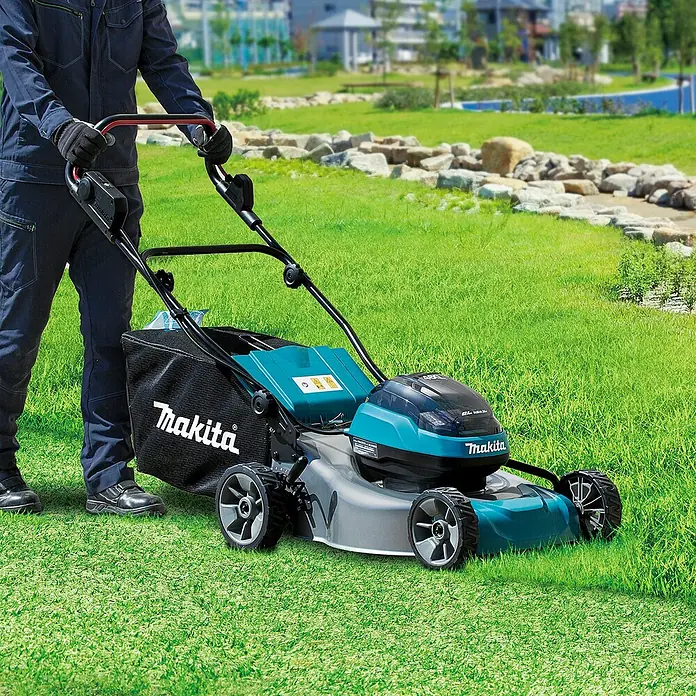 Makita LXT 18V Akku-Rasenmäher DLM466PT2 - 18 V, 2 Akkus, 5 Ah, Schnittbreite: 46 cm - Türkis-schwarzer Makita Rasenmäher, von einer Person auf Rasen bedient.