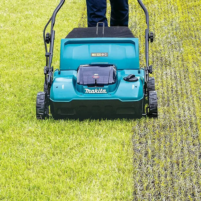 Makita XGT 40V max. Akku-Vertikutierer UV001GZ - Anzahl Akkus: Ohne Akku, 40 V, Arbeitsbreite: 38 cm - Türkiser und schwarzer Makita Rasenlüfter im Einsatz, zeigt gesunden Rasen links und vertikutierten Rasen rechts.
