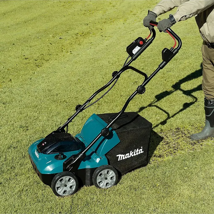 Makita XGT 40V max. Akku-Vertikutierer UV001GZ - Anzahl Akkus: Ohne Akku, 40 V, Arbeitsbreite: 38 cm - Eine Person bedient einen türkis-schwarzen Makita Vertikutierer und entfernt Rasenfilz.