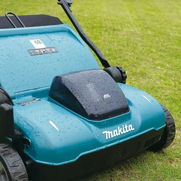 Makita LXT 18V Akku-Vertikutierer DUV320Z - Anzahl Akkus: Ohne Akku, 18 V, Arbeitsbreite: 32 cm - Nasser, türkisfarbener Makita Rasenmäher mit Wassertropfen auf der Oberfläche.