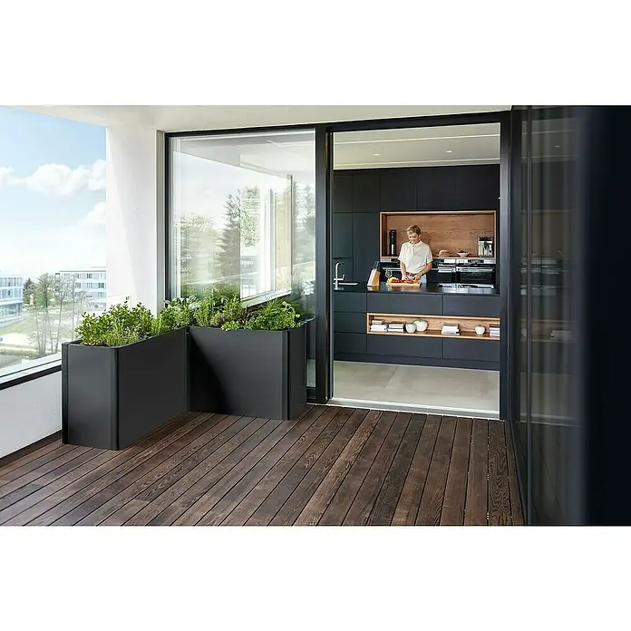Biohort Belvedere Hochbeet Belvedere - 152 x 152 x 77 cm, Stahl, Dunkelgrau Metallic - Dunkle L-förmige Pflanzgefäße mit Kräutern bilden einen Garten auf einem modernen Balkon, angrenzend an die Küche.