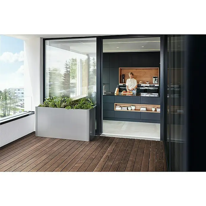 Biohort Belvedere Hochbeet - 53 x 152 x 77 cm, Stahl, Quarzgrau Metallic - Großer, grauer, rechteckiger Pflanzkasten mit Kräutern auf Balkon, neben Schiebetüren zur Küche.
