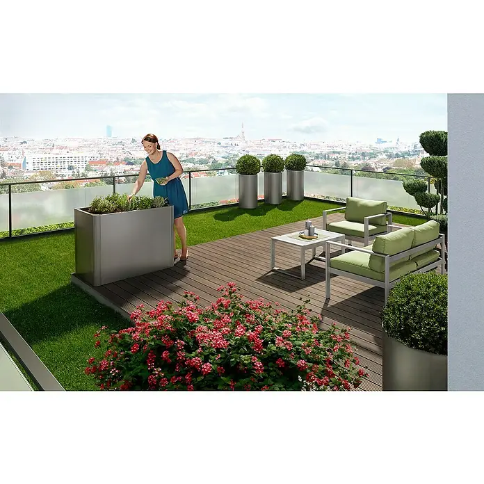 Biohort Belvedere Hochbeet - 53 x 102 x 77 cm, Stahl, Quarzgrau Metallic - Eine Frau pflegt Kräuter in einem großen, grauen Rechteck-Pflanzgefäß auf einer Dachterrasse mit passenden runden Pflanzgefäßen und Loungemöbeln.