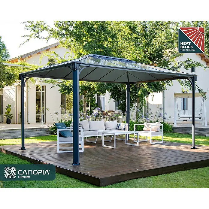 Palram – Canopia Standard-Pavillon Martinique 4300 - B x T: 430 x 295 cm, Farbe Gestell: Anthrazit, Aluminium - Dunkelgraues Metallpavillon mit lichtdurchlässigem Dach, das eine weiße Outdoor-Sofagarnitur auf einem Holzdeck in einem sonnigen Garten schützt.