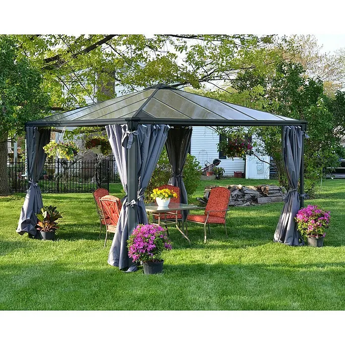 Palram – Canopia Standard-Pavillon Palermo 3600 - B x T: 360 x 360 cm, Material Gestell: Aluminium, Grau - Ein graues Metall-Gartenpavillon mit klarem Dach und gerafften grauen Vorhängen über roten Stühlen und einem Glastisch.