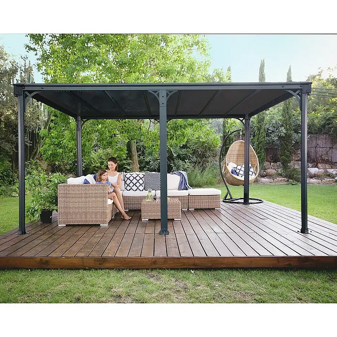 Palram – Canopia Pavillon Milano 4300 - B x T: 435,9 x 315,5 cm, Farbe Gestell: Anthrazit, Aluminium - Dunkelgrauer Pavillon mit Polycarbonatdach, spendet Schatten über Gartenmöbeln auf Holzterrasse.