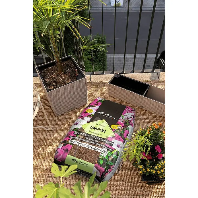 Lechuza Pflanzensubstrat Unipon - 40 l - Ein 40L Sack Lechuza UNIPON Universalerde für Außen- und Balkonpflanzen auf einem Balkon, neben Pflanzgefäßen und Pflanzen.