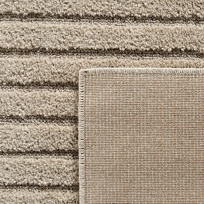 Kurzflorteppich Art 1123 - Beige, Durchmesser: 80 cm, 100 % Polypropylen - Beiger Teppich mit gestreiftem Flor, Ecke umgeklappt, um die gewebte Rückseite zu zeigen.