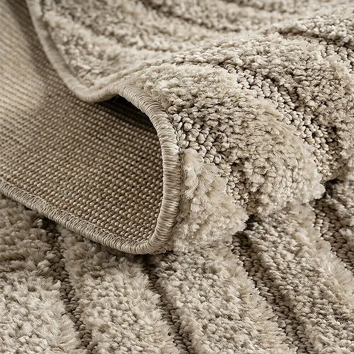 Kurzflorteppich Art 1122 - Beige, Durchmesser: 80 cm, 100 % Polypropylen - Weicher beigefarbener Hochflorteppich, gefaltet, zeigt seine plüschige Textur und robuste Geweberückseite.