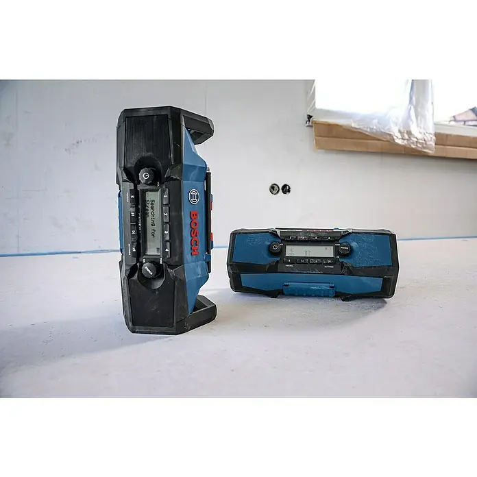 Bosch Professional AMPShare 18V Akku-Radio GPB 18V- 3 C SOLO K - 18 V, Ohne Akku - Zwei robuste, blau-schwarze Bosch Baustellenradios, eines stehend, eines liegend, auf einer Baustelle.
