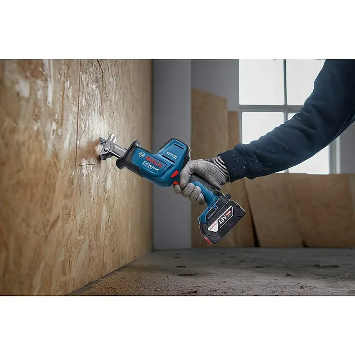 Bosch Professional AMPShare 18V Akku-Säbelsäge GSA 18V-24 -  - Akku-Bosch-Säbelsäge (blau/schwarz) schneidet Holz. Eine Person hält die Säge in eine OSB-Platte.