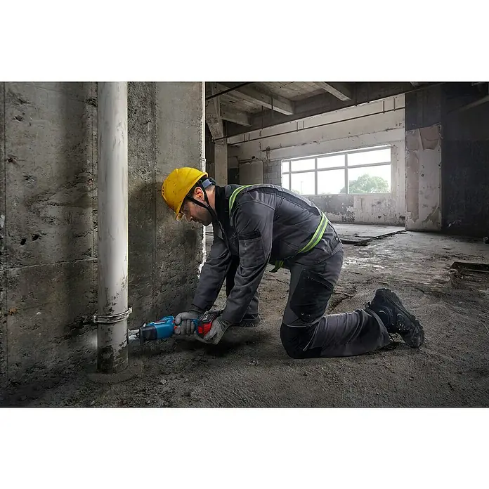 Bosch Professional AMPShare 18V Akku-Säbelsäge GSA 18V-24 -  - Arbeiter nutzt eine blau-schwarze Säbelsäge, um ein Rohr in einem Rohbau zu schneiden.