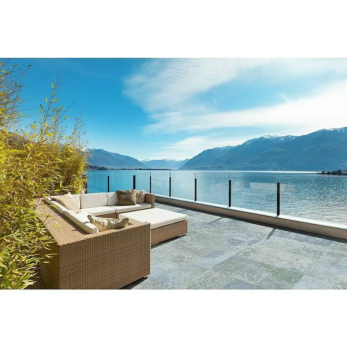 Bohemian Feinsteinzeugfliese - 59,55 x 59,55 cm, Blue, Matt - Outdoor Rattan-Ecksofa mit cremefarbenen Kissen auf einer Terrasse mit See- und Bergblick.