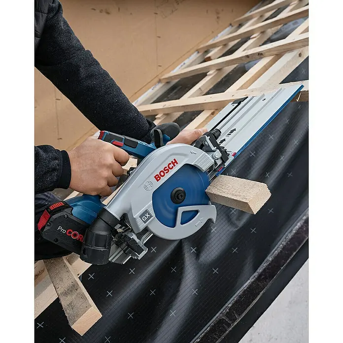 Bosch Professional Führungsschiene FSN 740 X - L x B x H: 1.083 x 228 x 49 mm - Person schneidet Holz auf einem Dach mit einer blauen und grauen Bosch Akku-Handkreissäge und Führungsschiene.