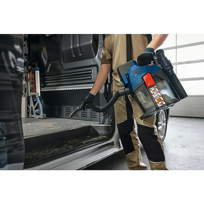 Bosch Professional AMPShare 18V Akku-Staubsauger GAS 18V-6 LS - 18 V, Behältervolumen: 4,5 l - Blauer und schwarzer Bosch GAS 18V-10 L Profi-Sauger reinigt Sägemehl aus einem Lieferwagen.